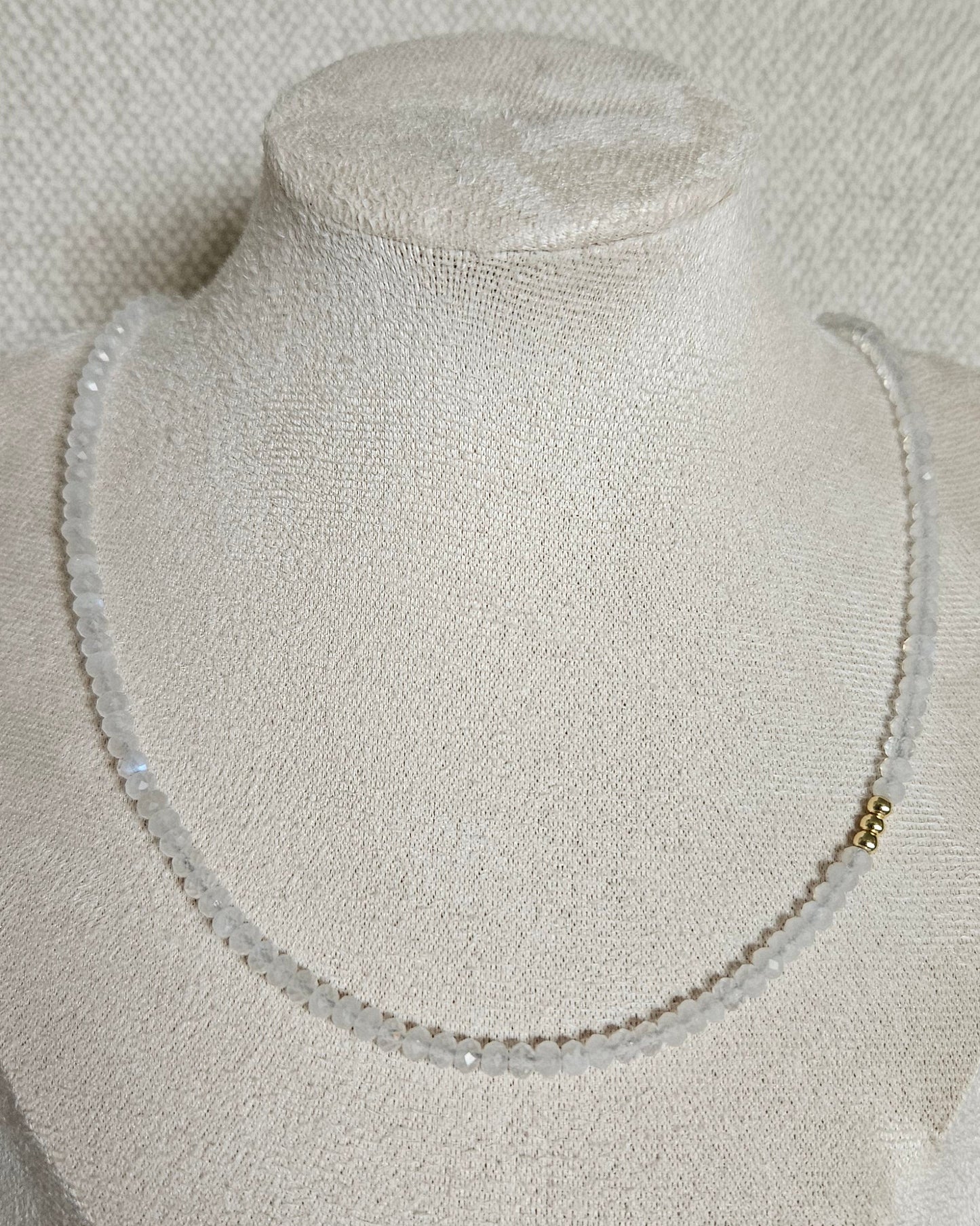 Faceted Moonstone rondelle necklace with gold-plated accents displayed on a beige jewellery bust
