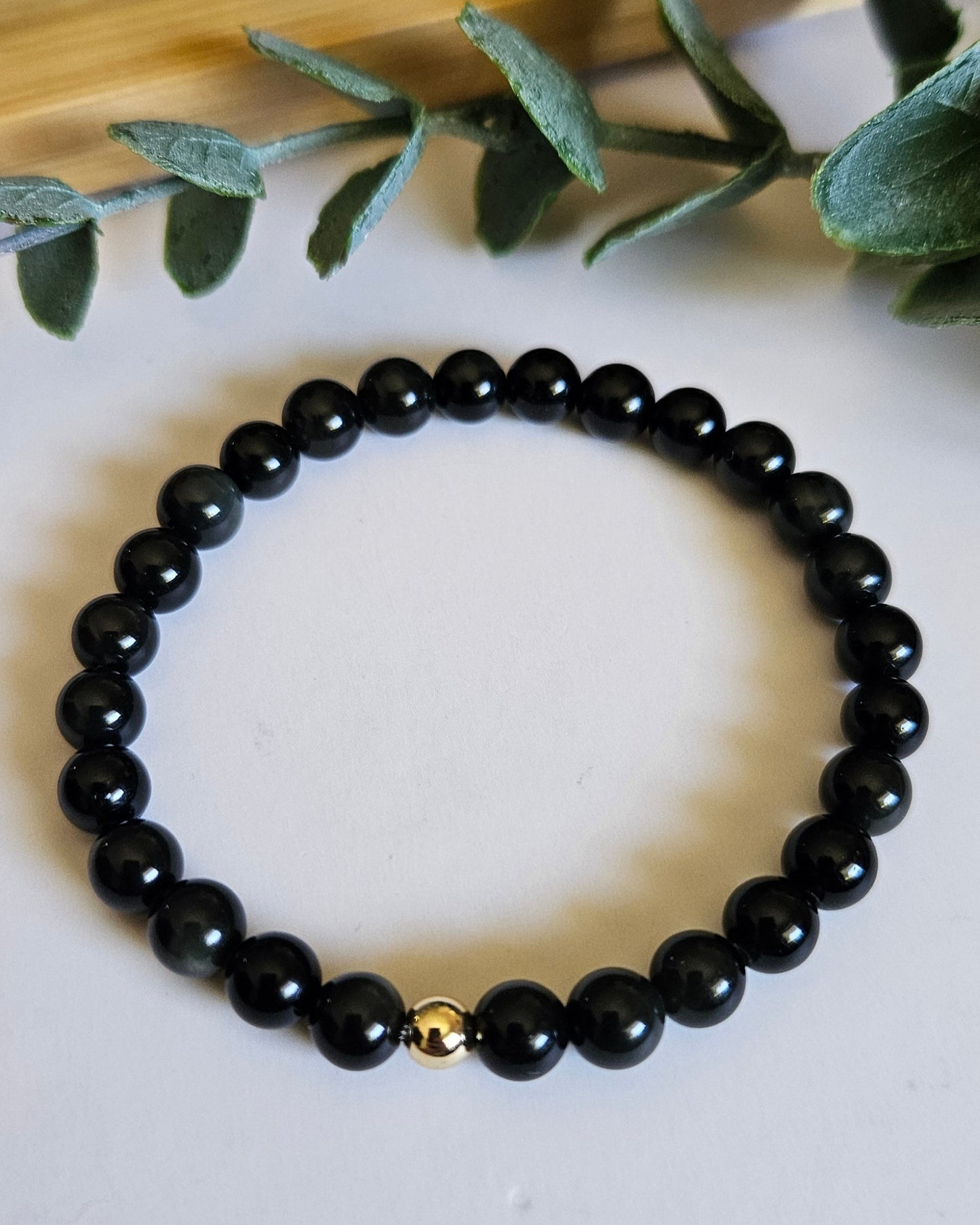 Black beaded bracelet with a gold accent