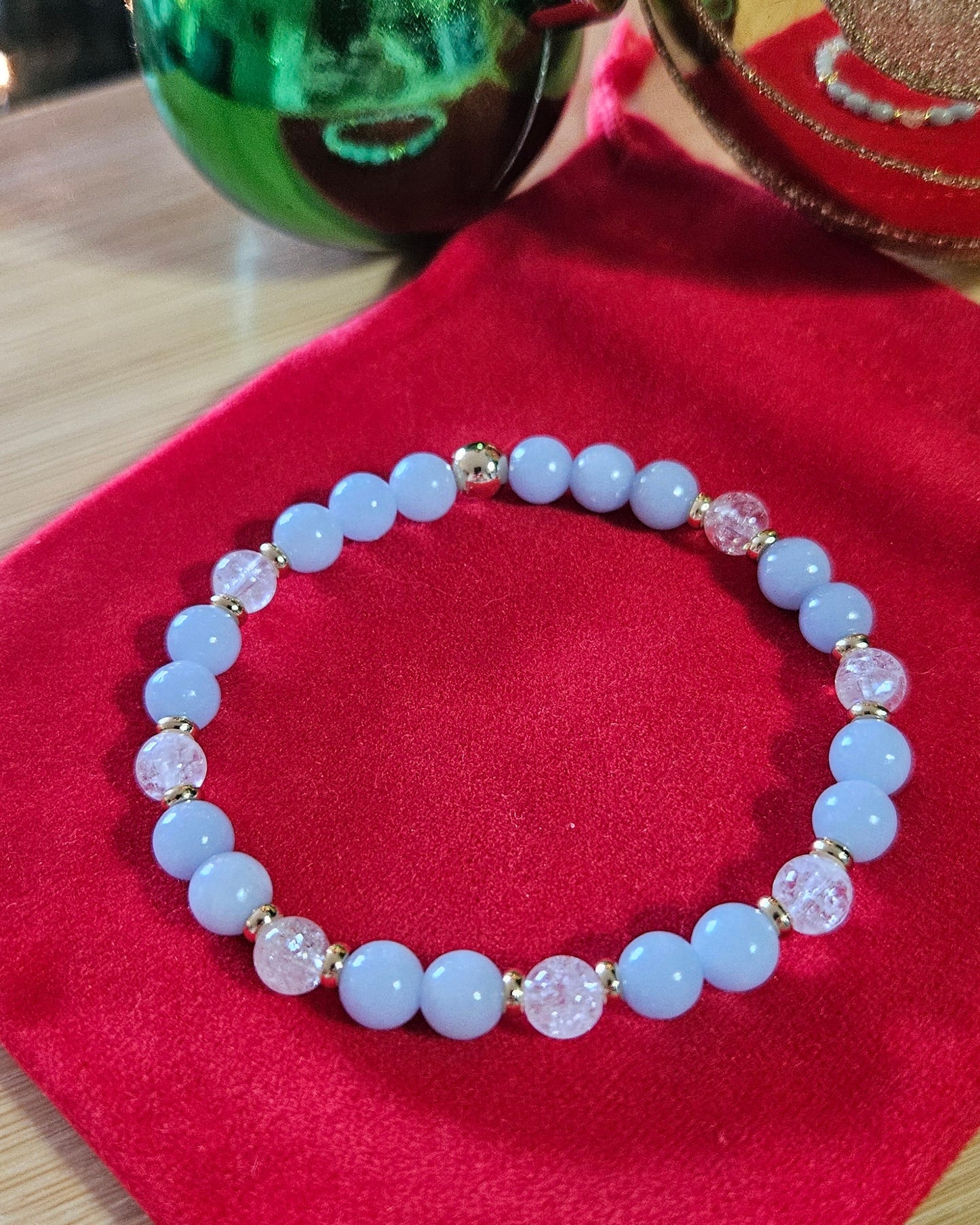 Blue beaded bracelet on a red surface with a blurred background