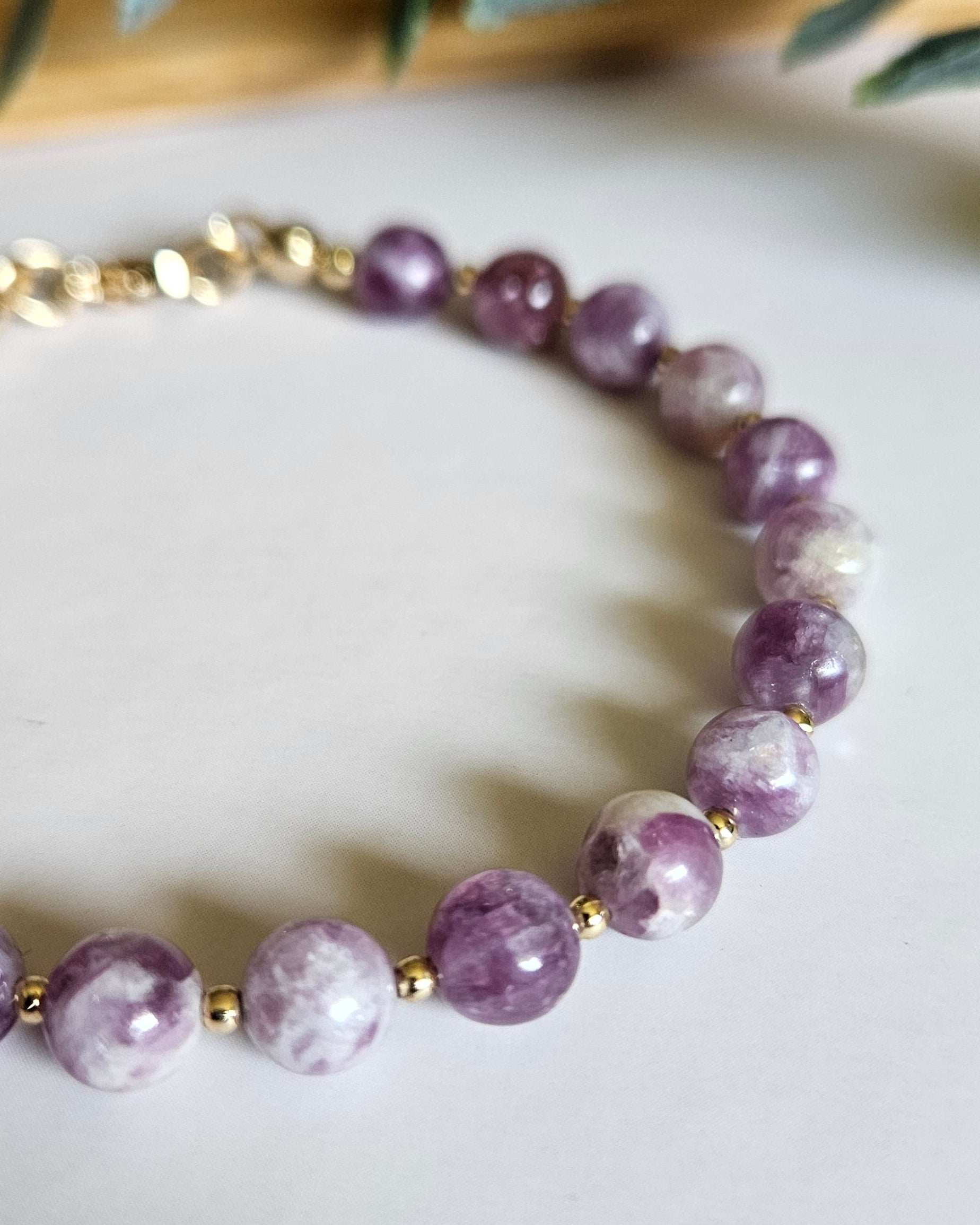 Purple beaded bracelet with gold accents