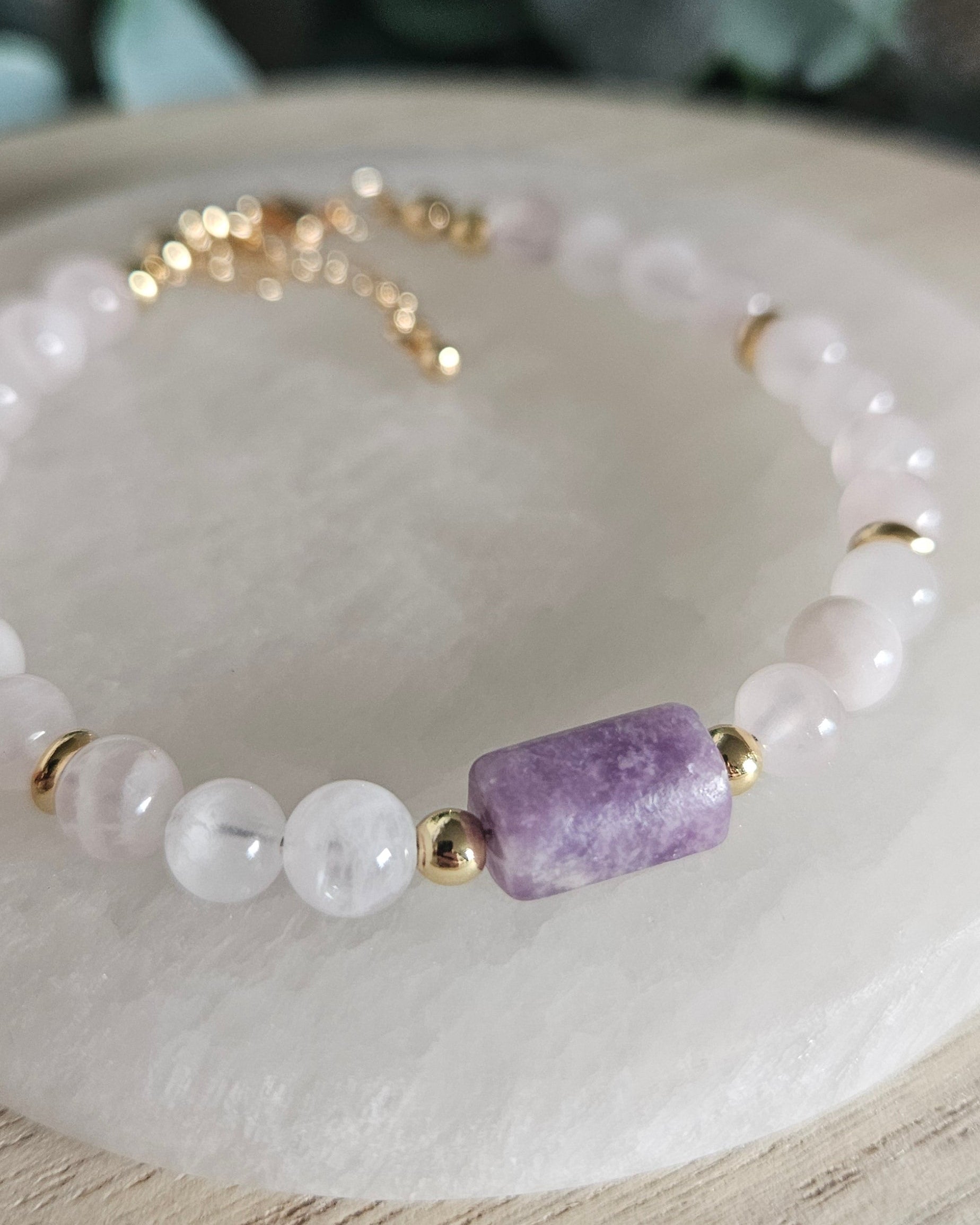 Macro close-up of the purple Lepidolite focal stone, Rose Quartz beads and polished gold-plated accents