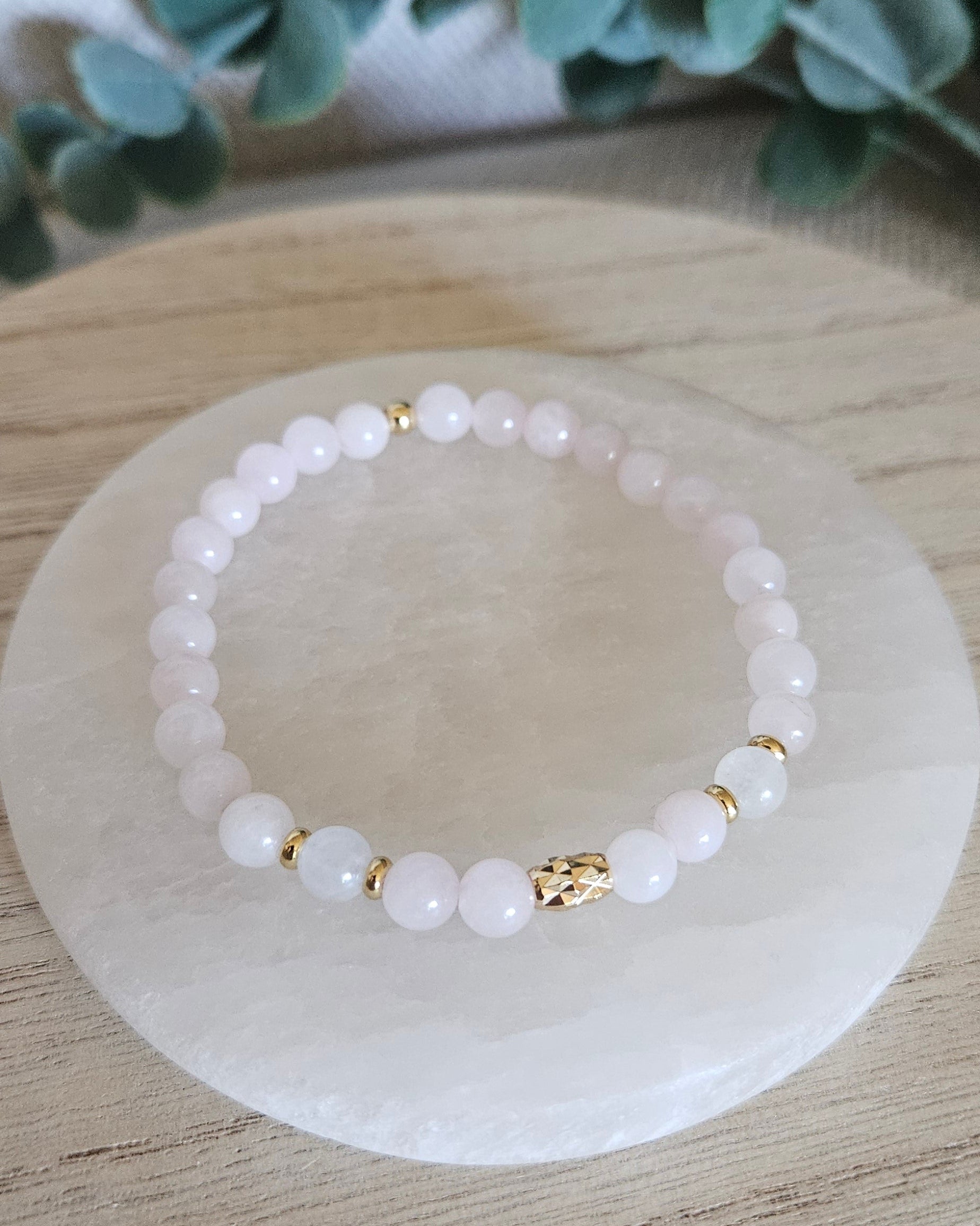 Overhead view of the pale pink Rose Quartz and Moonstone bracelet with decorative gold focal bead