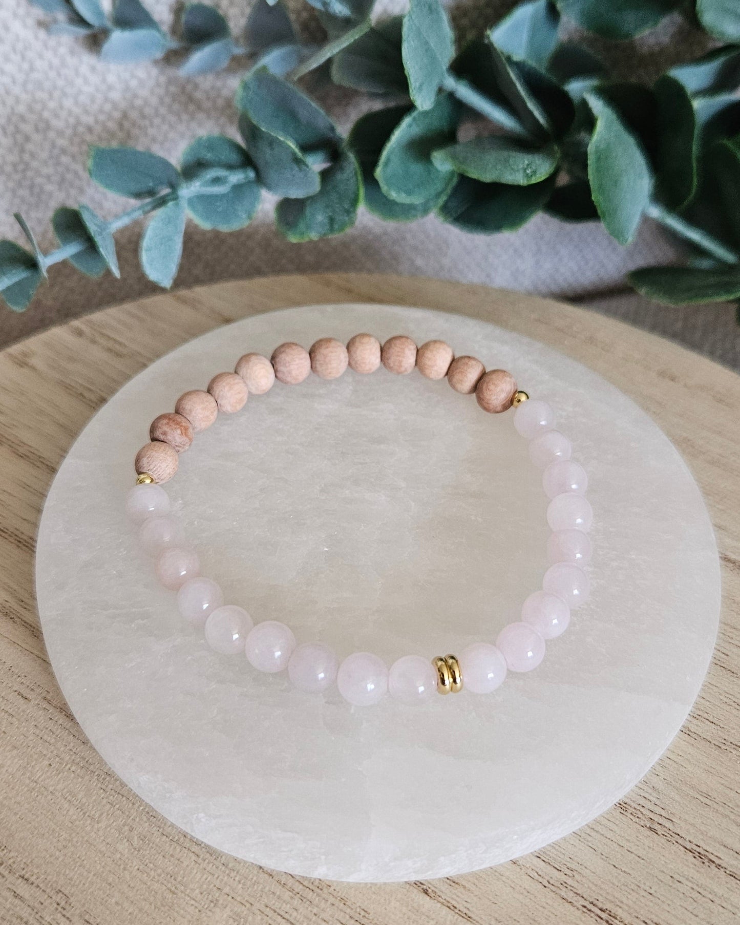 Overhead view of the Rose Quartz diffuser bracelet with natural Rosewood beads for essential oils