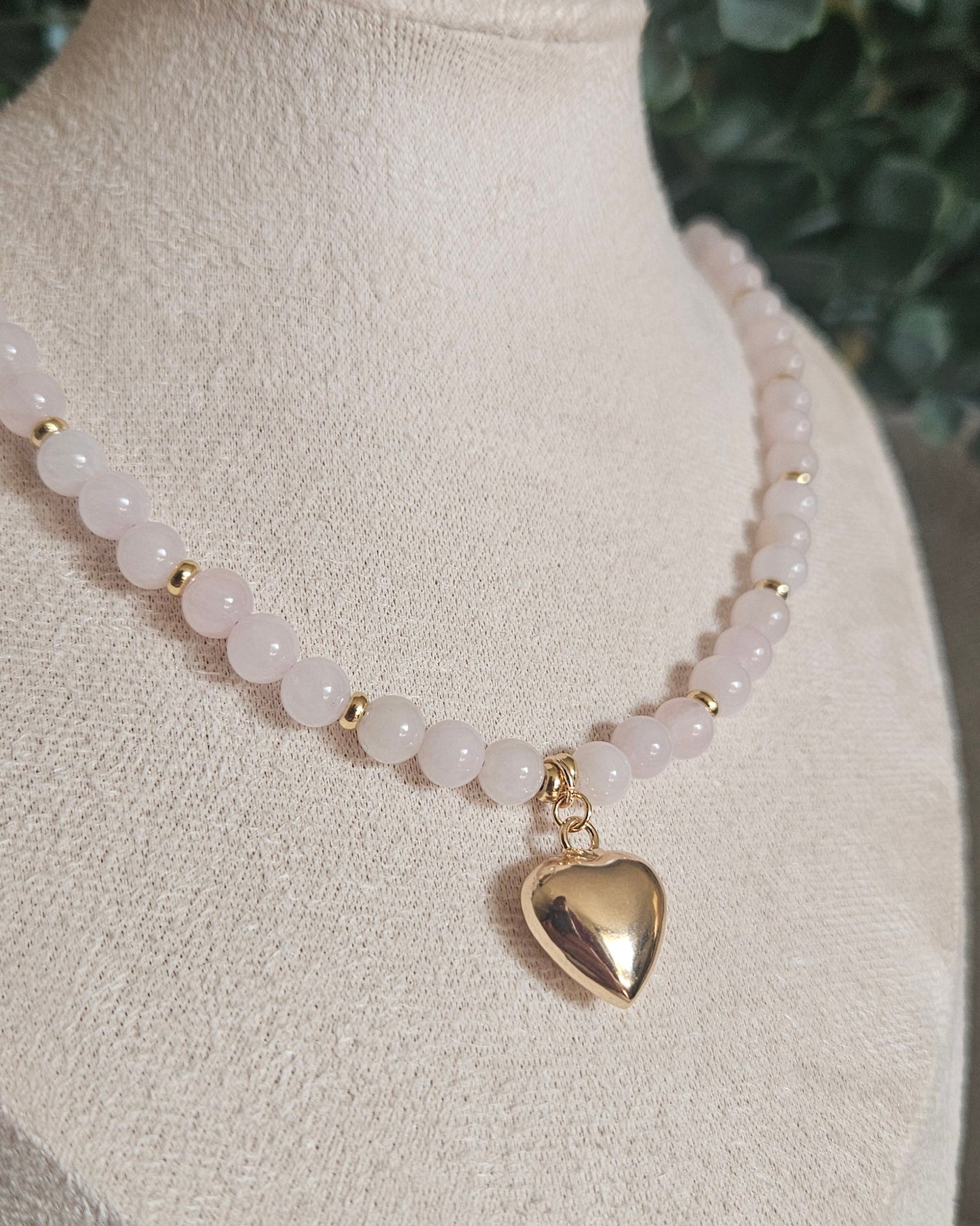 Angled close-up of the Rose Quartz necklace, gold-plated spacer beads and polished gold-filled heart pendant