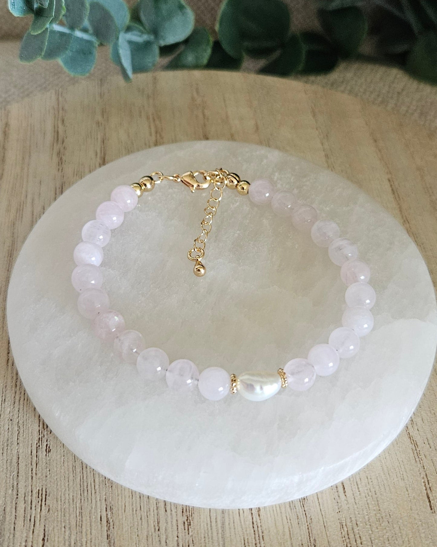 Rose Quartz Bracelet with a freshwater pearl focal and gold accents on selenite plate