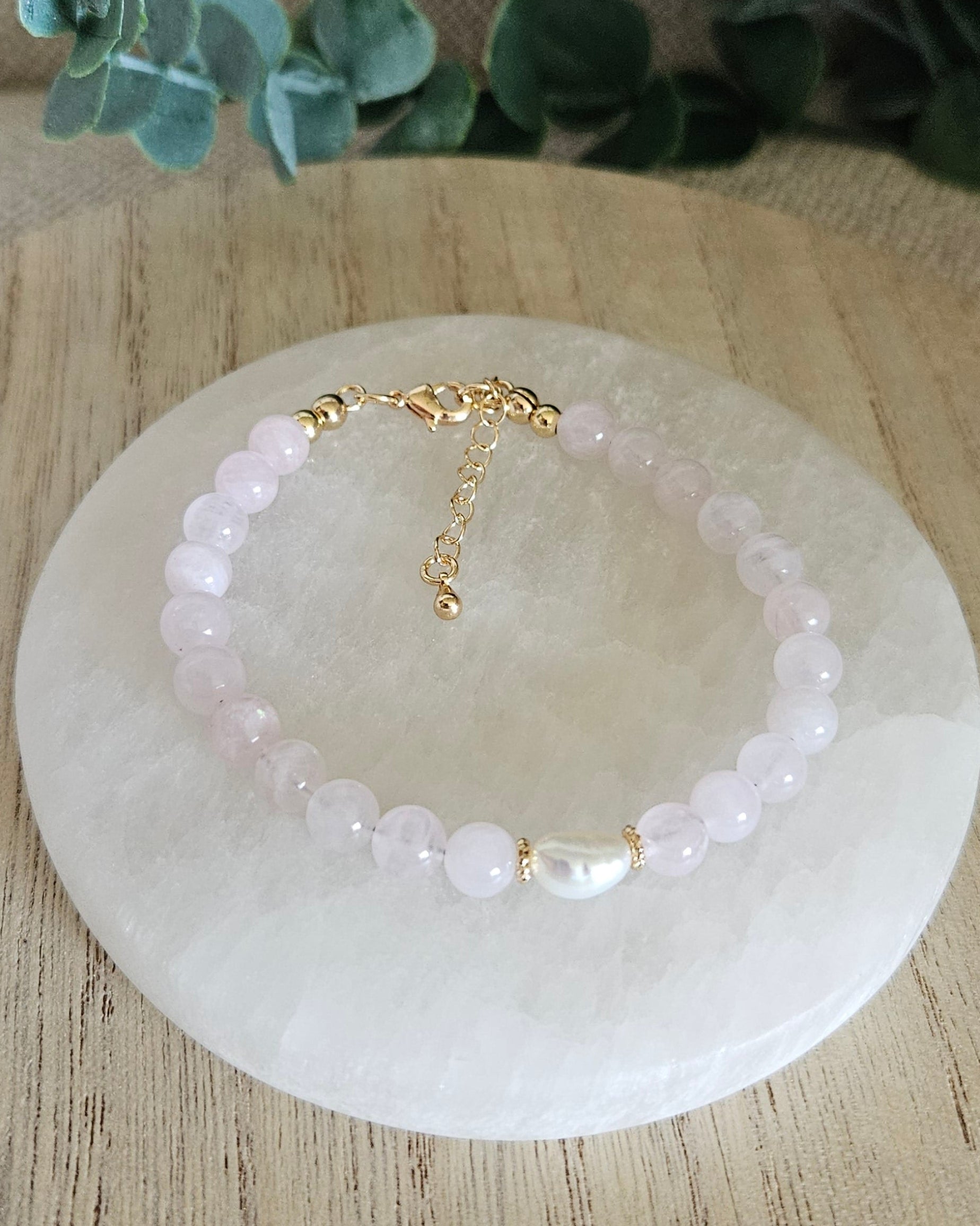 Rose Quartz Bracelet with a freshwater pearl focal and gold accents on selenite plate