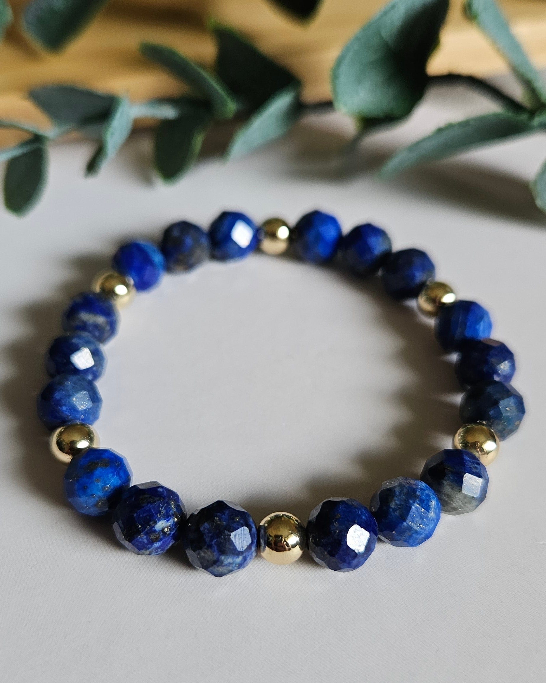 Handcrafted Lapis Lazuli bracelet with 14k gold-plated accents promoting wisdom, truth, and self-expression