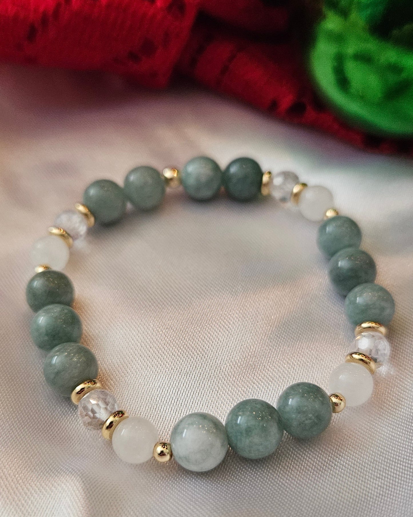 Green beaded bracelet on a white fabric background