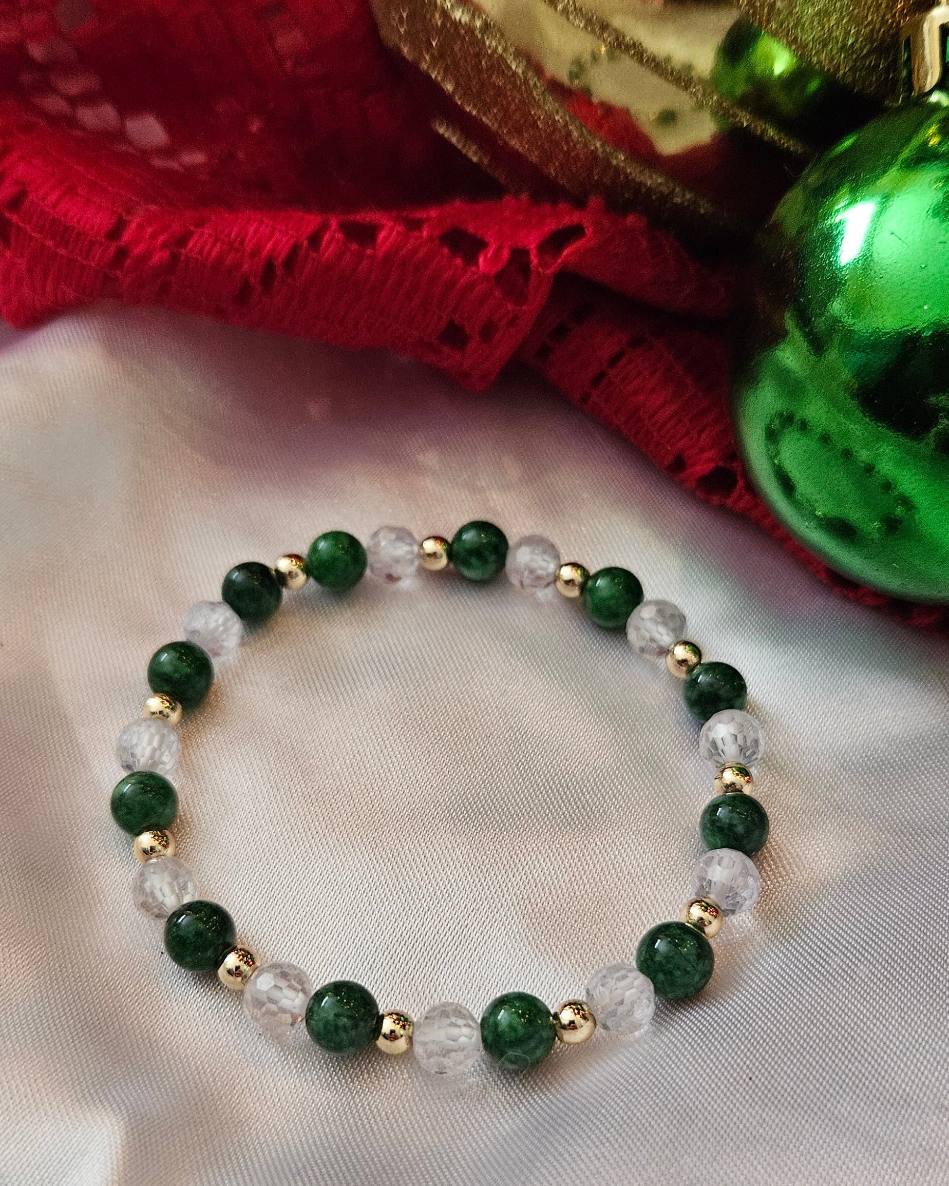 Green beaded bracelet on a white fabric background