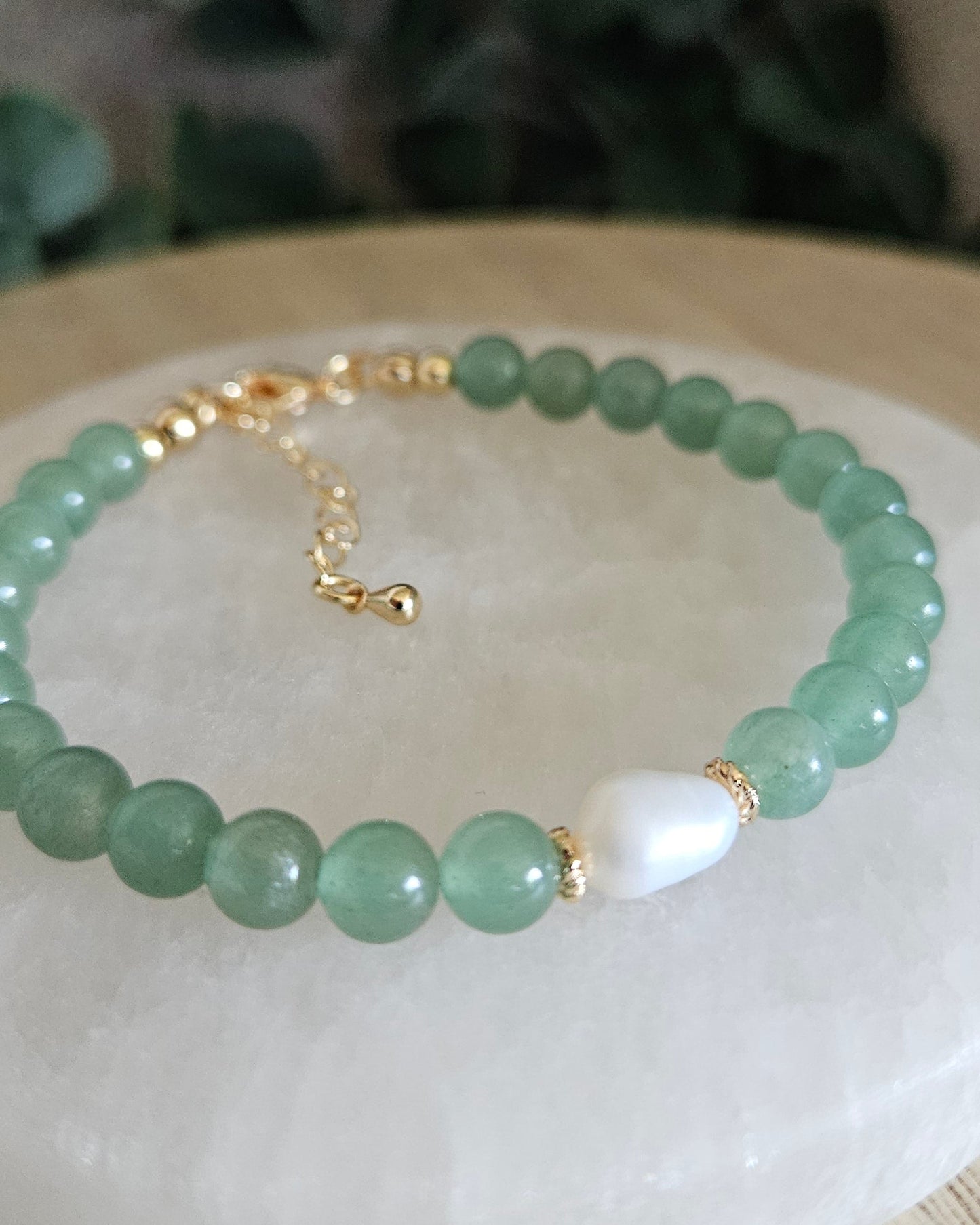 green bracelet with freshwater pearl on selenite plate