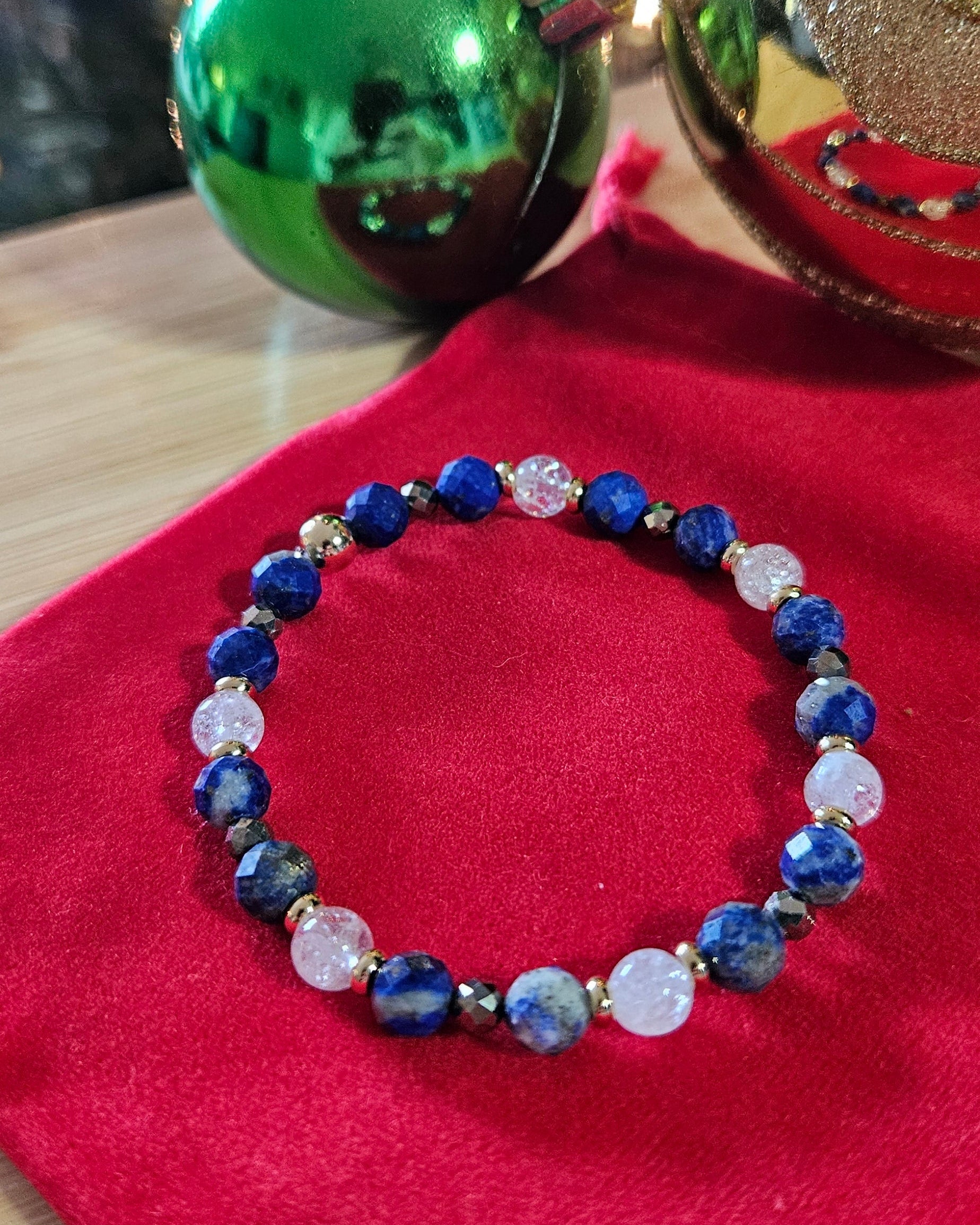 Blue beaded bracelet on a red surface with blurred background