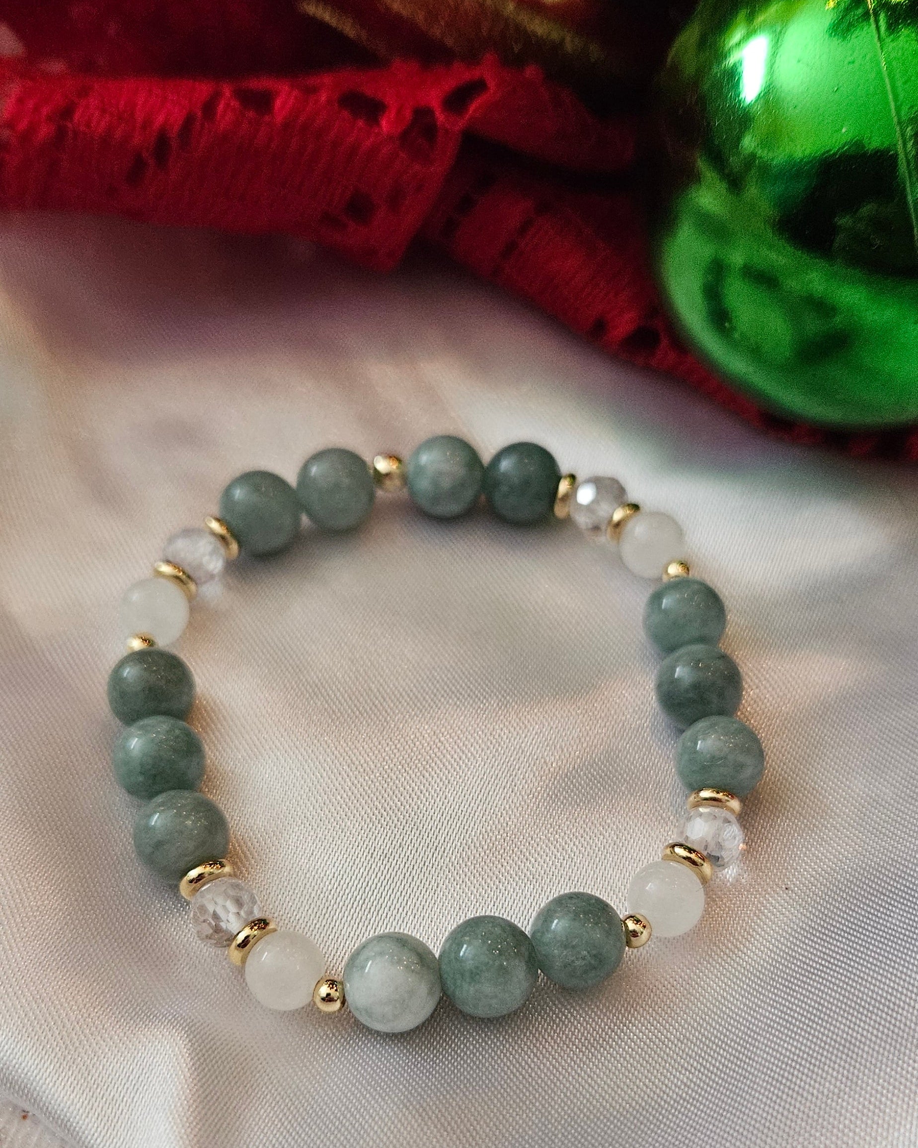 Green beaded bracelet on a textured fabric background