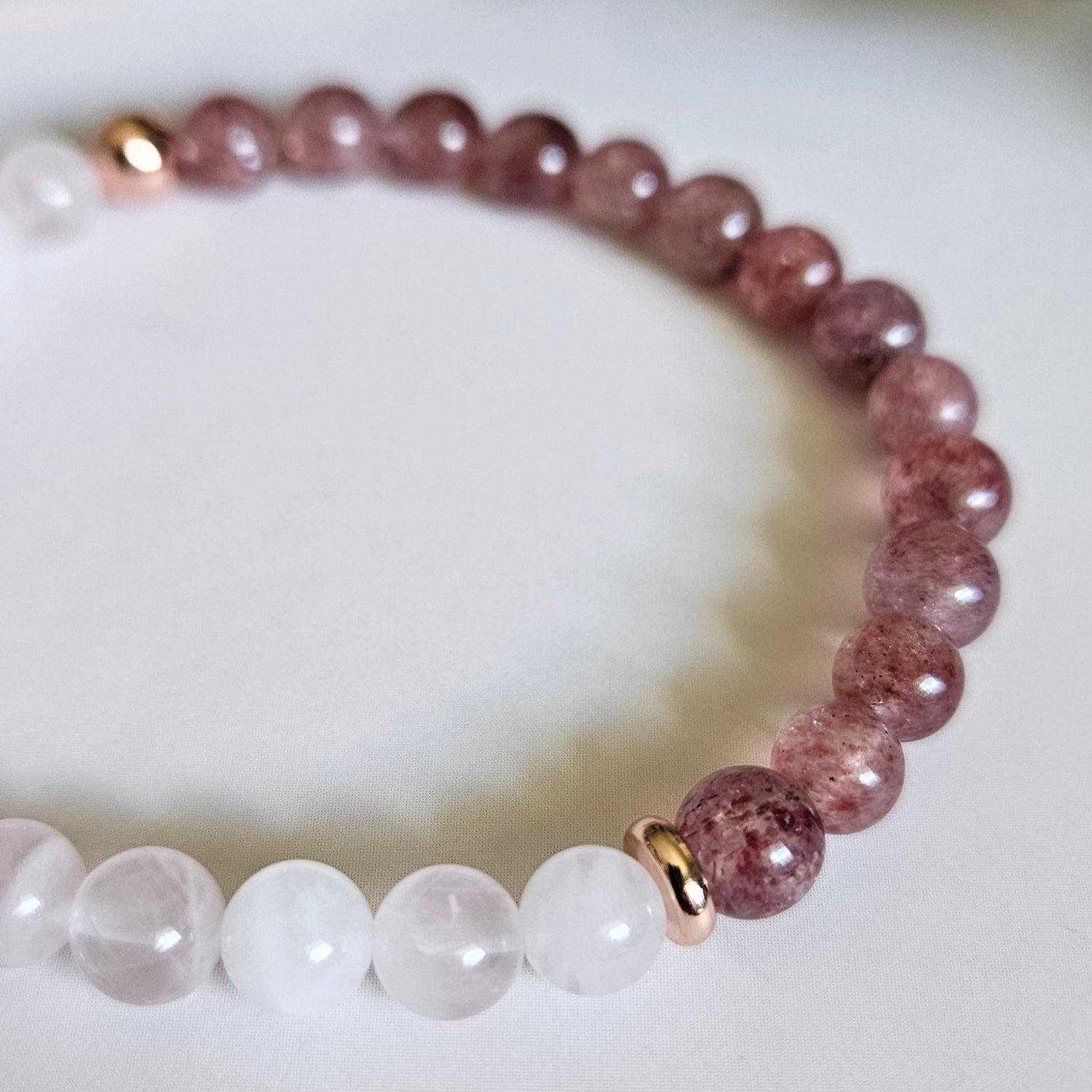 Bracelet with pink and white beads on a white background