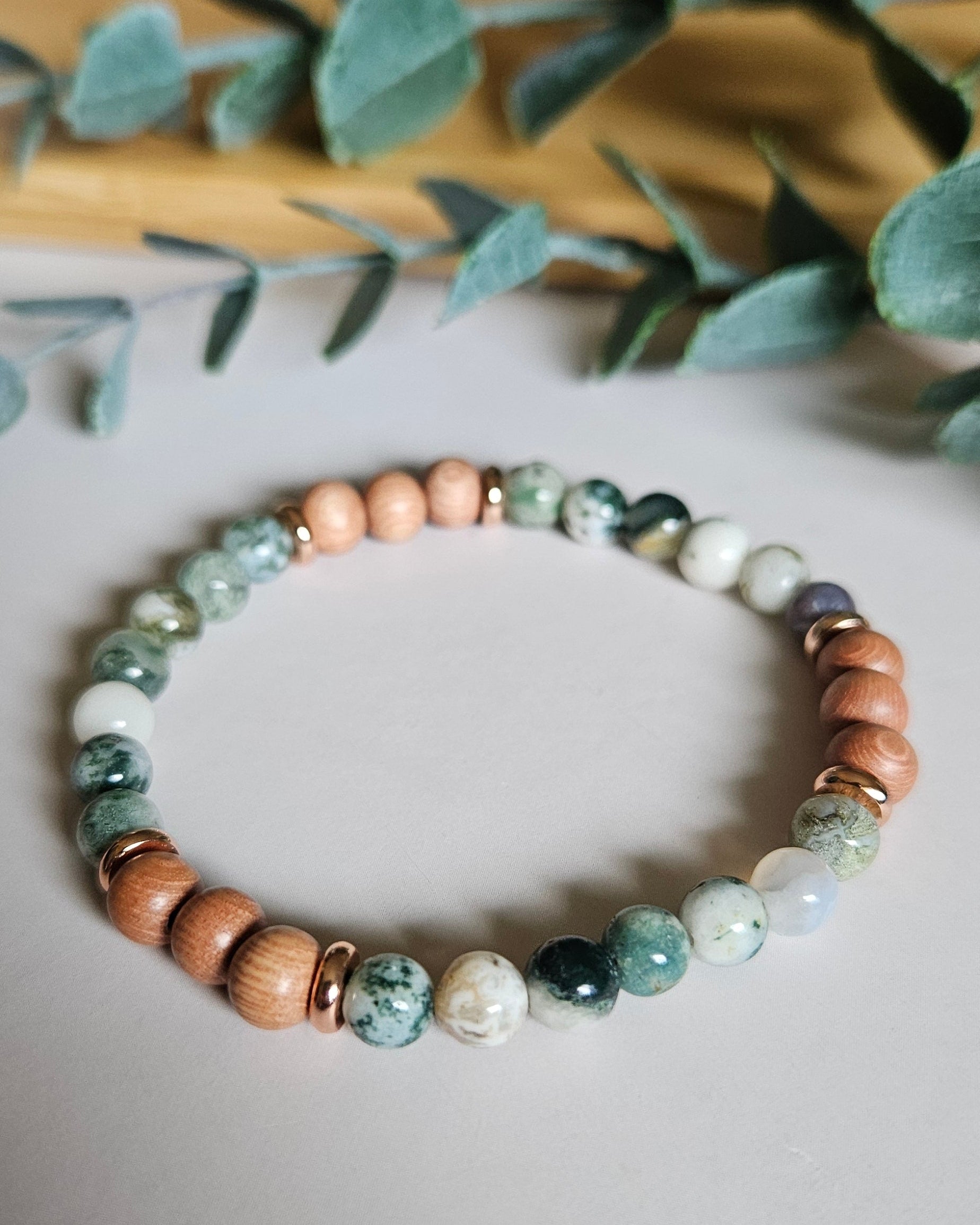 Beaded bracelet on a light surface with a blurred plant in the background